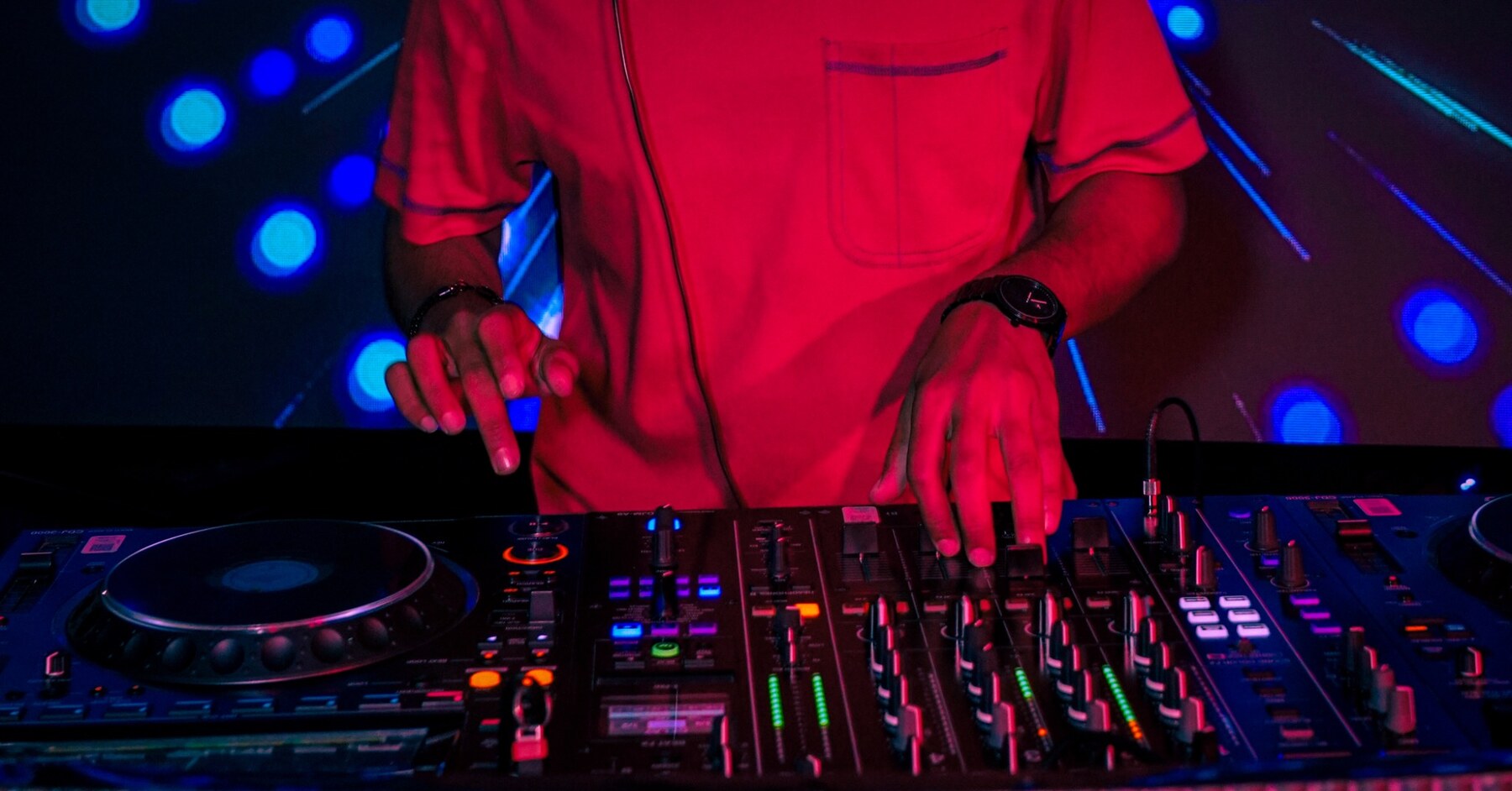 ICEY mixing on a club controller under red and blue lights